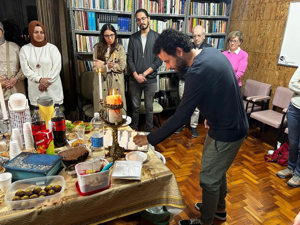 Membro das Famílias Abraâmicas acendendo uma vela.
